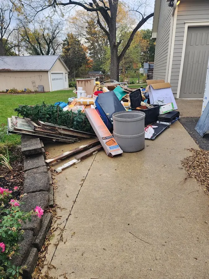 Dumpster being loaded with debris for Estate Cleanout Dumpster Rental in Pella